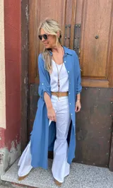 Sobrecamisa larga azul de viscosa con cuello camisero, manga larga con puños abotonados y tajos laterales.