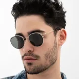 Lentes de sol INVU con montura redonda plateada y lentes polarizadas grises.