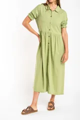 Vestido midi verde claro de lino, con cuello camisero, mangas cortas abullonadas y abotonadura frontal.