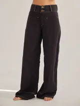 Pantalón negro de tiro medio alto, corte palazzo, con bolsillos delanteros y traseros.