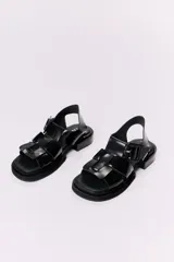 Sandalias de cuero color marrón con tiras anchas cruzadas y hebilla cuadrada.