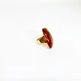Anillo artesanal de resina color ámbar con base de acero dorado y tamaño regulable.
