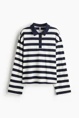 Remera polo de manga larga con cuello clásico y tapeta de botones. Diseño a rayas horizontales blancas y azul marino.