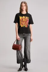 Remera negra de algodón con calce regular, cuello redondo y mangas cortas. Estampa frontal con la frase "Tastes Like Paradise" en letras rojas y amarillas.