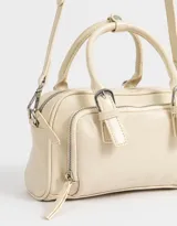 Cartera bowling color crudo con efecto craquelado, doble asa corta, correa larga regulable y desmontable, cierre superior, bolsillo frontal con cierre y hebillas decorativas.