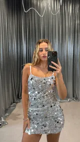 Minivestido plateado con lentejuelas, breteles finos y corte ajustado.