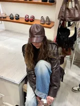 Gorra marrón de cuero con visera y ajuste trasero.