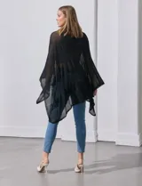 Poncho negro de tejido calado con lurex, terminación asimétrica y cuello redondo.