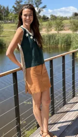 Top color beige de cuero con flecos en los laterales y caracoles buzios en el frente. Espalda tejida.