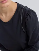 Remera gris claro de algodón con mangas largas abullonadas y escote en V.