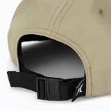 Gorra estilo trucker o snapback de color beige, con visera plana y cordón decorativo marrón cruzando el frente. Presenta el logo "HURLEY" bordado en blanco en el panel frontal.