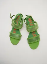 Sandalias de gamuza color negro con tiras transparentes de poliuretano, taco redondo y tiras finas al tobillo.