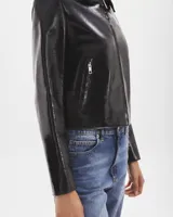 Campera de cuero negra, con corte ajustado y cierre frontal, diseño minimalista.