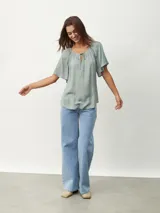 Blusa blanca de mangas cortas con escote redondo y lazos.
