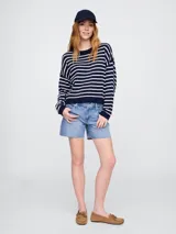 Sweater de punto color verde claro con rayas horizontales blancas, de corte holgado y cuello redondo.