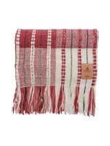 Bufanda larga tejida a mano en lana merino, viscosa y lino, con diseño a rayas horizontales en tonos crudo, rojo y negro. Aplique de cuero con logo grabado de la colaboración Manos + PQ.