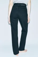 Pantalón de jean negro de tiro alto, corte slim y largo hasta el tobillo.