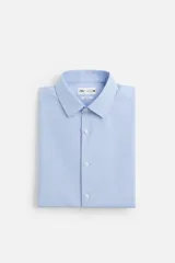 Camisa celeste de corte slim fit, confeccionada en tejido de algodón. Tiene cuello italiano, mangas largas con puños abotonados y cierre frontal con botones.