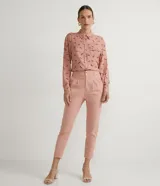 Camisa de viscosa color rosa con estampado de caballos en marrón. Tiene cuello camisero, cierre con botones, mangas largas, un bolsillo frontal y detalle de vivo contrastante.
