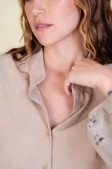 Camisa azul con cuello mao y mangas largas caladas con diseño geométrico.