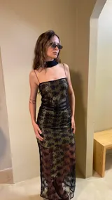 Vestido largo negro con estampado dorado, de breteles finos y corte ajustado.