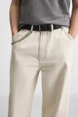 Pantalón de jean color crudo, corte relaxed fit, con bolsillos frontales y traseros tipo parche. Tiene tira multifunción y bolsillo tipo parche en las piernas.