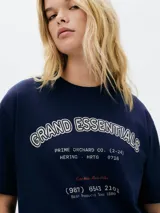 Remera color crema de corte amplio con estampa de un pescado y texto en azul marino.