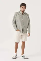 Camisa de lino color blanco, de corte regular, con cuello clásico y mangas largas.