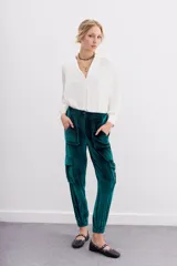 Pantalón babucha verde esmeralda de terciopelo con elástico en la botamanga, bolsillos plaqué en el frente con remaches metálicos y bolsillos cargo en las piernas.