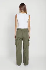 Pantalón negro de corte ancho con cintura elastizada y cordón ajustable. Presenta una franja vertical blanca a lo largo de la pierna y un bolsillo tipo cargo en el muslo.
