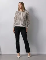 Blusa de gasa estampada a rayas verticales blancas y negras, marca Sioni. Espalda con abertura y botón. Manga larga con puño y botón.