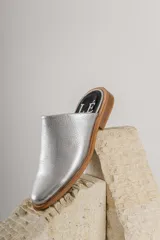 Zapatilla de cuero plateado con tacón bajo, diseño slip-on.