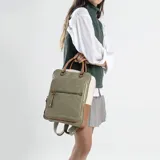 Mochila combinada en tres tonos de símil cuero: marrón, beige y negro. Tiene doble bolsillo frontal, asa de mano y correas regulables. En su interior tiene dos bolsillos con cierre y uno abierto con división para celular.