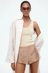 Musculosa de punto fino color beige, entallada, con escote en U en la parte delantera y trasera.