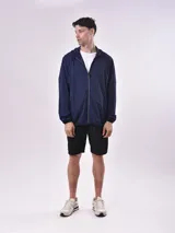 Campera azul marino con capucha y cierre frontal.