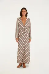 Camisa larga de viscosa con estampado de rayas verticales en tonos crudo, verde y borgoña. Tiene escote en V profundo con cordones para anudar y mangas largas fluidas.