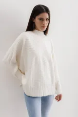 Sweater de punto color crudo, con cuello alto y textura acanalada con diseño geométrico.