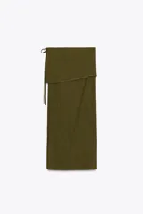 Falda larga color verde oliva, de tiro medio y corte recto. Presenta una superposición de tela tipo pareo ajustable con lazadas.
