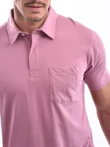 Chomba manga corta color rosa con cuello clásico y bolsillo en el pecho.