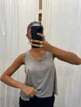 Musculosa gris de poliéster y rayón con spandex, escote en V y breteles anchos.