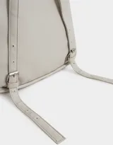 Mochila negra de cuerina con correas regulables, manija superior, cierre superior con doble deslizador, bolsillo frontal con cierre y deslizador, etiqueta metálica y bolsillos laterales.