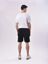 Bermuda color gris con cintura elástica ajustable con cordón, bolsillos laterales y un bolsillo tipo cargo en la pierna izquierda.