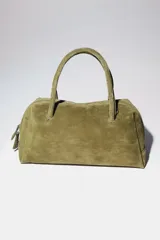Bolso tipo bowling color verde oliva, confeccionado en cuero. Tiene doble asa corta y cierre superior con doble cremallera.
