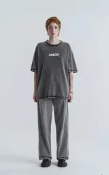 Remera negra con efecto gastado, cuello redondo y estampado frontal con la palabra 'Amor' en blanco.