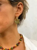 Aro tipo argolla dorado en acero quirúrgico con dije colgante de flor acrílica color verde militar.