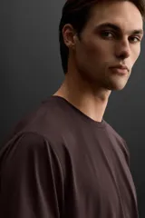 Camiseta deportiva marrón de tejido técnico ligero y elástico con estructura. Cuello redondo, manga corta, costuras planas y logo estampado.