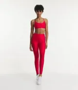 Calza legging deportiva roja de poliamida y elastano, con cintura alta, recortes y bolsillo lateral.
