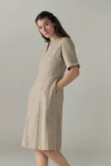 Vestido midi de corte elegante, color beige, con escote en V y mangas 3/4.