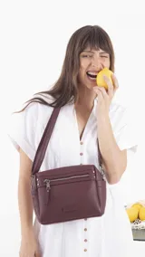 Bandolera color beige con correa extensible, cierre principal y bolsillos interiores, un bolsillo frontal, un bolsillo posterior y bolsillos laterales.