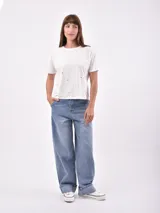 Remera blanca de algodón con cuello redondo y mangas cortas.